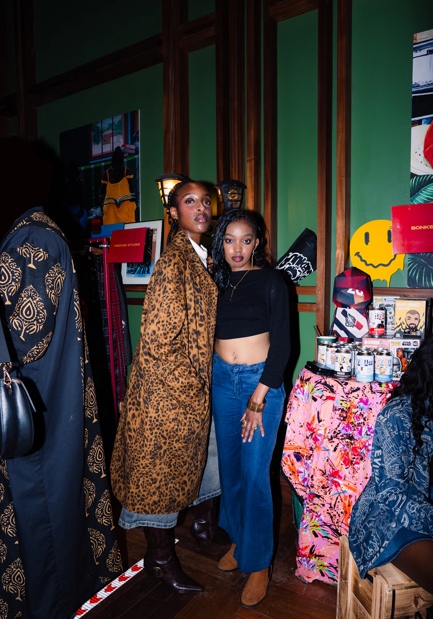 Two women shopping between clothing racks in a boutique